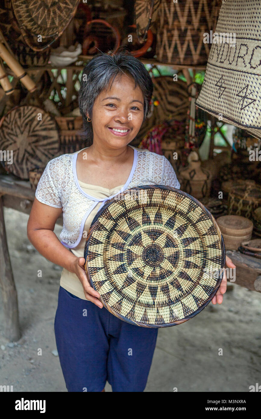 Aninuan, Oriental Mindoro, Philippines - A Mangyan craftswoman displays a nito platter she wove from rattan strips at her village of Sitio Talipanan. Stock Photo