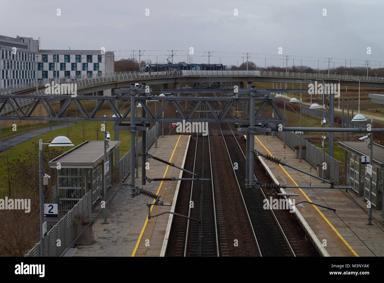A photograph of the Edinburgh Park rail station in Edinburgh, Scotland, as a tram is arriving from the airport. Stock Photo
