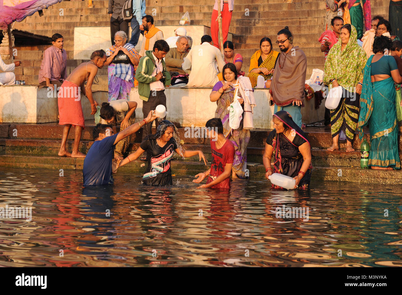 Devotees on the banks of the river Ganges take a holy dip in Varanasi, India Stock Photo