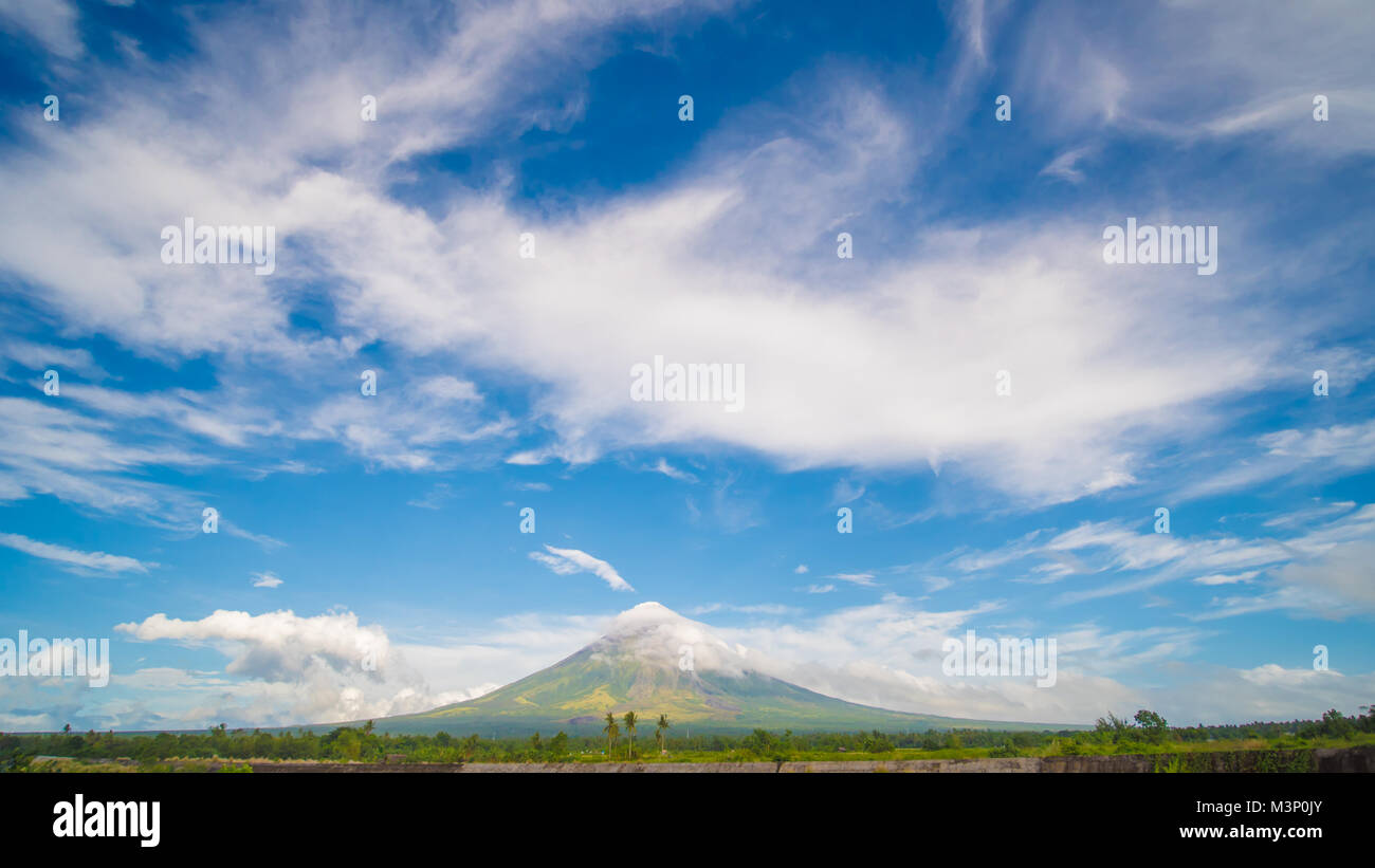 Mayon Volcano is an active stratovolcano in the province of Albay in Bicol Region, on the island of Luzon in the Philippines. Renowned as the perfect cone because of its symmetric conical shape. Stock Photo