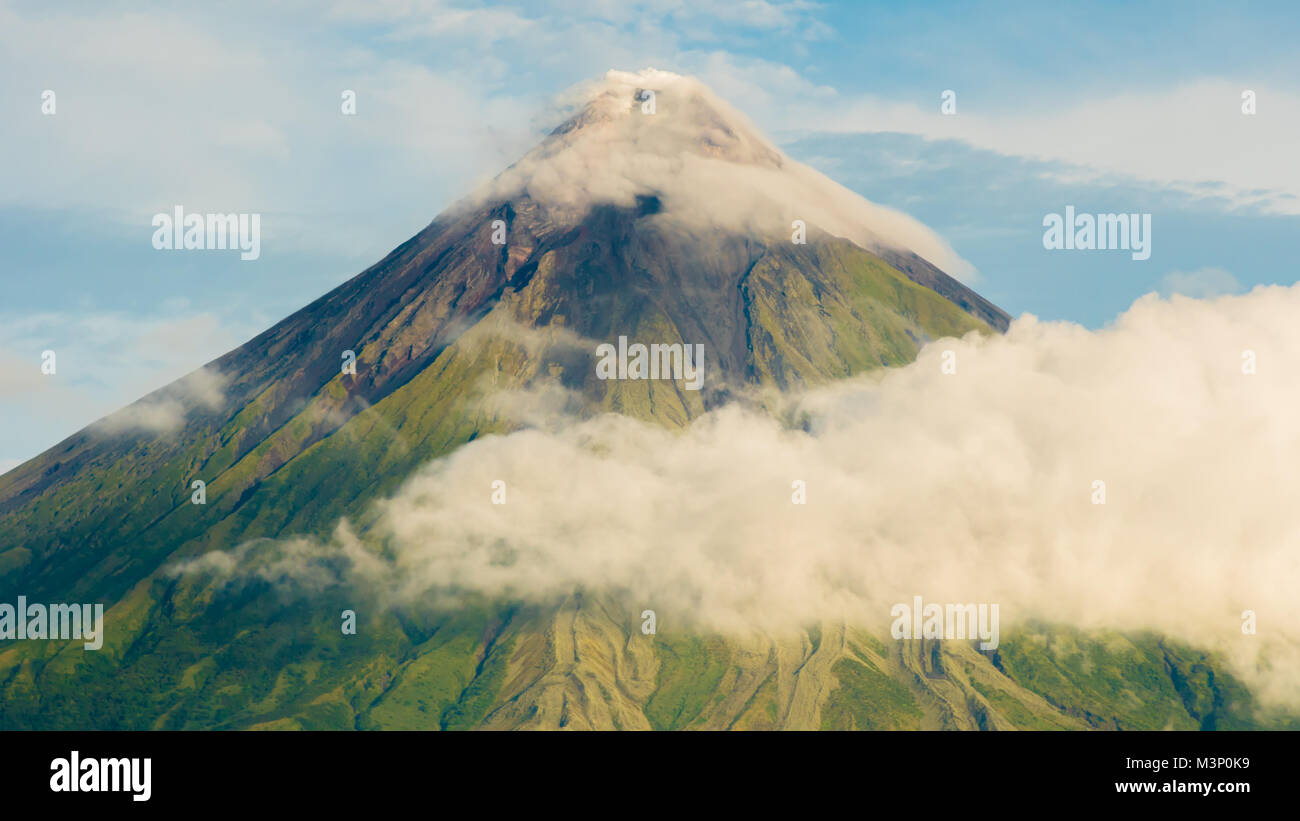 Mayon Volcano is an active stratovolcano in the province of Albay in Bicol Region, on the island of Luzon in the Philippines. Renowned as the perfect cone because of its symmetric conical shape. Stock Photo