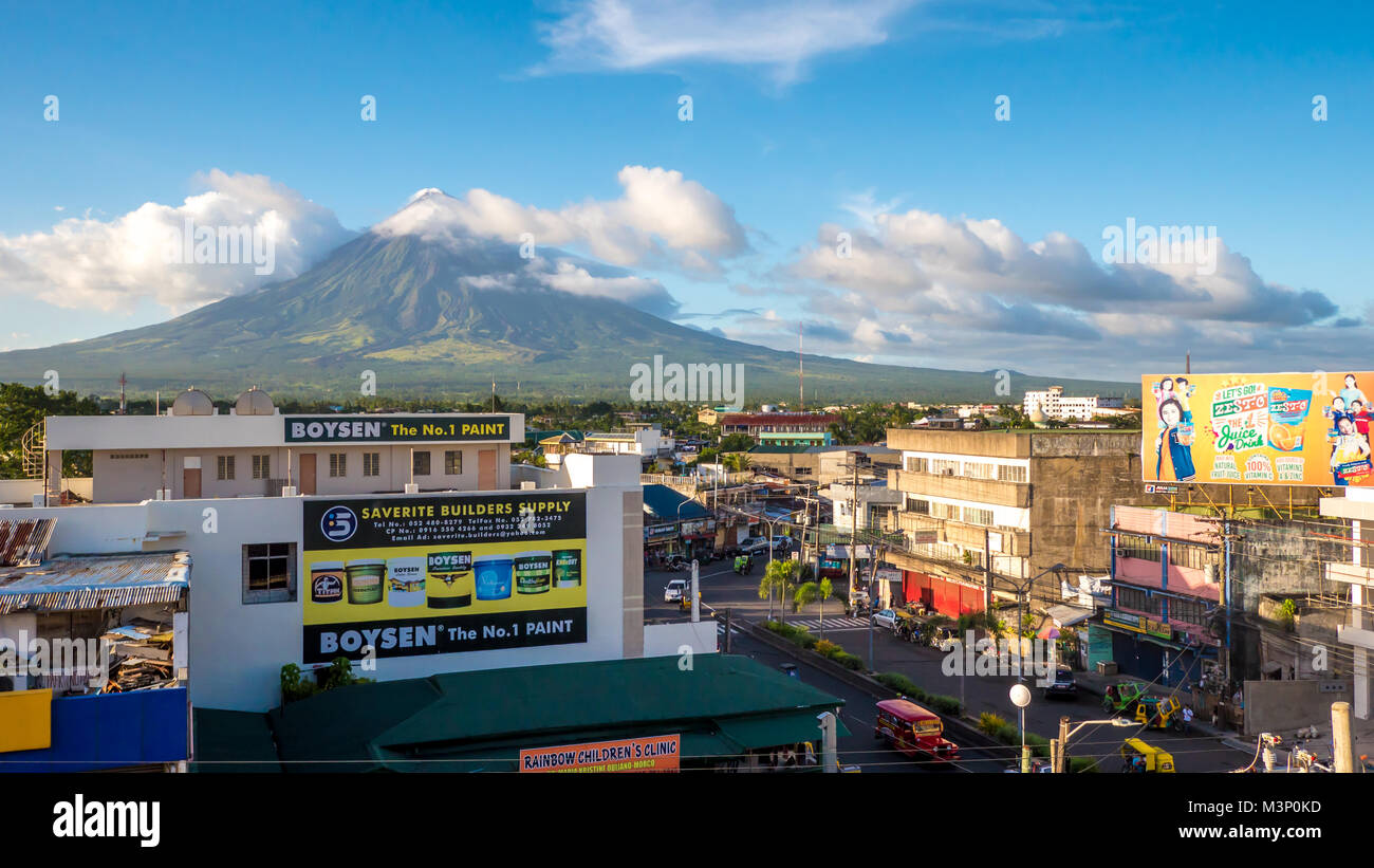 LEGAZPI, PHILIPPINES - JANUARY 5, 2018: - Mount Mayon volcano looms over the city as daily life goes on. Stock Photo