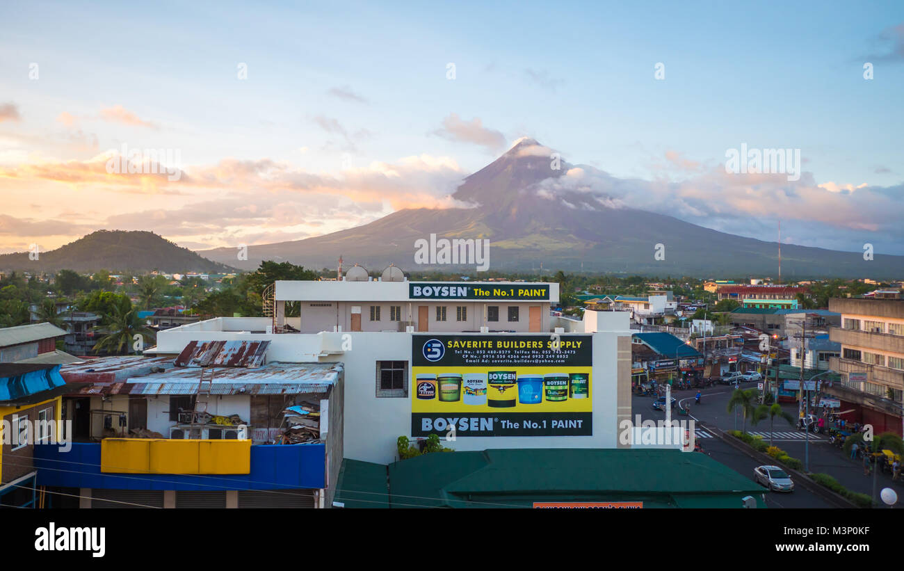 LEGAZPI, PHILIPPINES - JANUARY 5, 2018: - Mount Mayon volcano looms over the city as daily life goes on. Stock Photo