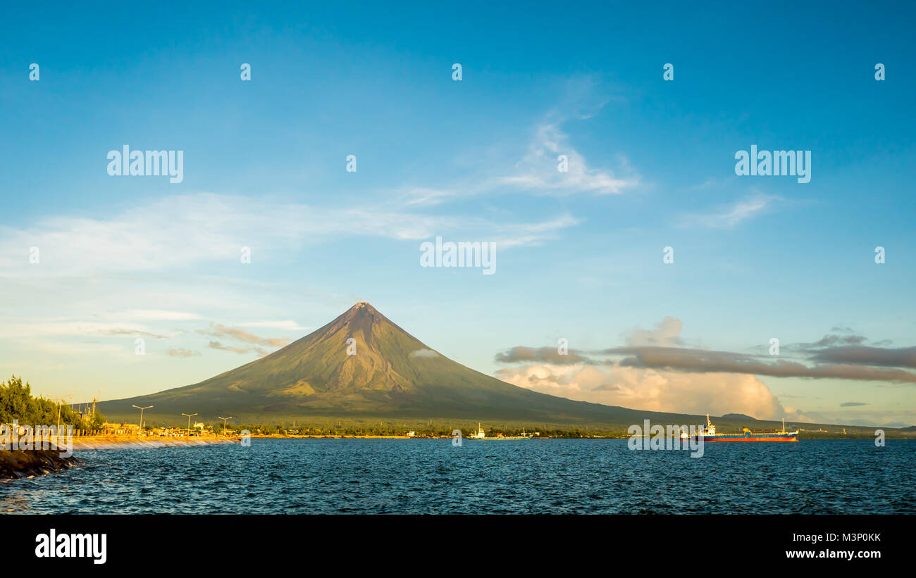 Mayon Volcano is an active stratovolcano in the province of Albay in Bicol Region, on the island of Luzon in the Philippines. Renowned as the perfect cone because of its symmetric conical shape. Stock Photo