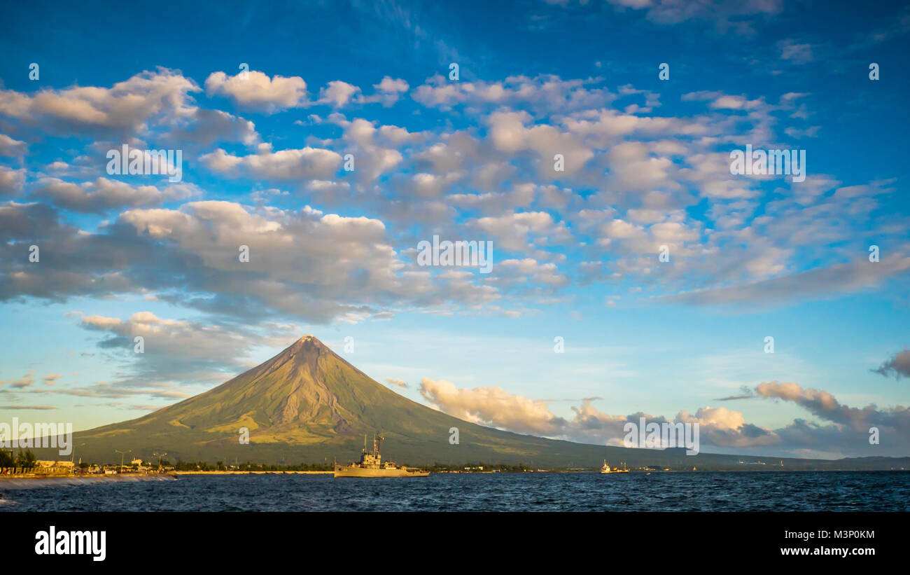 Mayon Volcano is an active stratovolcano in the province of Albay in Bicol Region, on the island of Luzon in the Philippines. Renowned as the perfect cone because of its symmetric conical shape. Stock Photo