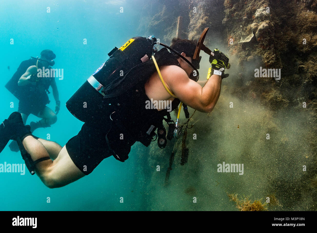 U.S. Navy Diver 2nd Class Logan Peters, assigned to Mobile Diving Salvage Unit (MDSU) 1, conducts an underwater pier survey with divers from Underwater Construction Team (UCT) 2 in Apra Harbor, Guam, Dec 14, 2017.  UCT-2 provides construction, inspection, maintenance, and repair of underwater and waterfront facilities in support of the Pacific Fleet. (U.S. Navy Combat Camera photo by Mass Communication Specialist 1st Class Arthurgwain L. Marquez) U.S. Navy divers conduct underwater pier survey in Apra Harbor, Guam by #PACOM Stock Photo