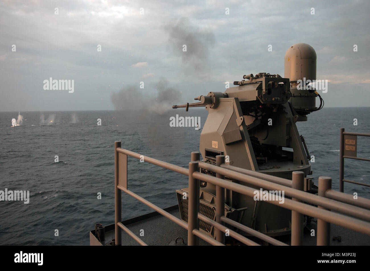 171220-N-ZS023-059 INDIAN OCEAN (Dec. 20, 2017) A Mark 38 Mod. II machine gun system aboard the amphibious assault ship USS America (LHA 6) fires 25mm rounds during a live fire exercise on the starboard weather deck. America, part of the America Amphibious Ready Group, with embarked 15th Marine Expeditionary Unit, is operating in the Indo-Asia Pacific region to strengthen partnerships and serve as a ready-response force for any type of contingency. (U.S. Navy photo by Mass Communication Specialist 3rd Class Vance Hand/Released) Service members train with a Mark 38 Mod. II machine gun system ab Stock Photo