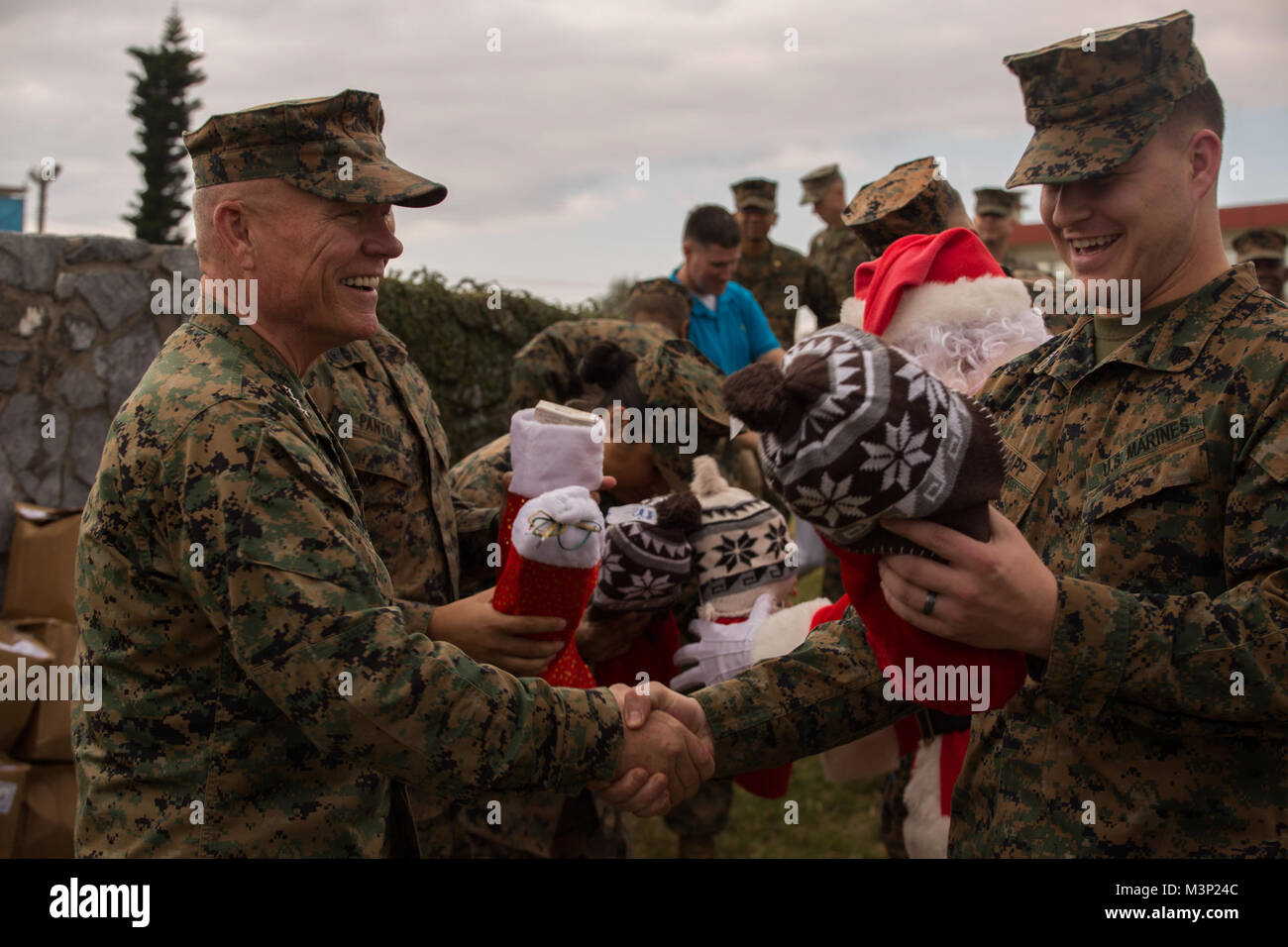 Lt. Gen. Lawrence D. Nicholson, the commanding general of III Marine Expeditionary Force, hands out Christmas stockings to Marines at Camp Courtney, Okinawa, Japan, Dec. 22, 2017.  Nicholson, alongside Santa Claus, wished the Marines happy holidays and provided gifts from volunteer organizations to the III MEF command element to spread Christmas cheer. (U.S. Marine Corps photo by Cpl. Nelson Duenas/released) III MEF General Spreads Christmas Cheer to his Marines in Okinawa, Japan by #PACOM Stock Photo
