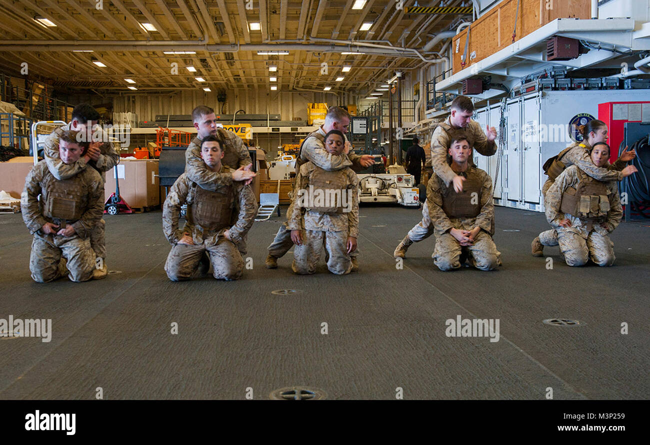 180102-N-ZS023-032 CELEBES SEA (Jan. 2, 2018) Marines assigned to the 15th Marine Expeditionary Unit (MEU) aboard the amphibious assault ship USS America (LHA 6), participate in Marine Corps martial arts program training in the hangar bay. America, part of the America Amphibious Ready Group, with embarked 15th MEU, is operating in the Indo-Asia Pacific region to strengthen partnerships and serve as a ready-response force for any type of contingency. (U.S. Navy photo by Mass Communication Specialist 3rd Class Vance Hand/Released) U.S. Marines with the 15th Marine Expeditionary Unit participate  Stock Photo