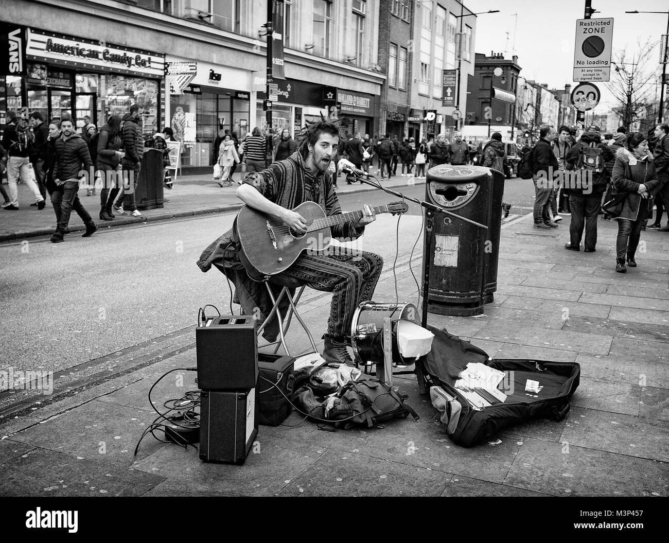Black & White Photograph of a busker playing his guitar, Camden Town, North London, England, UK. Credit: London Snapper Stock Photo