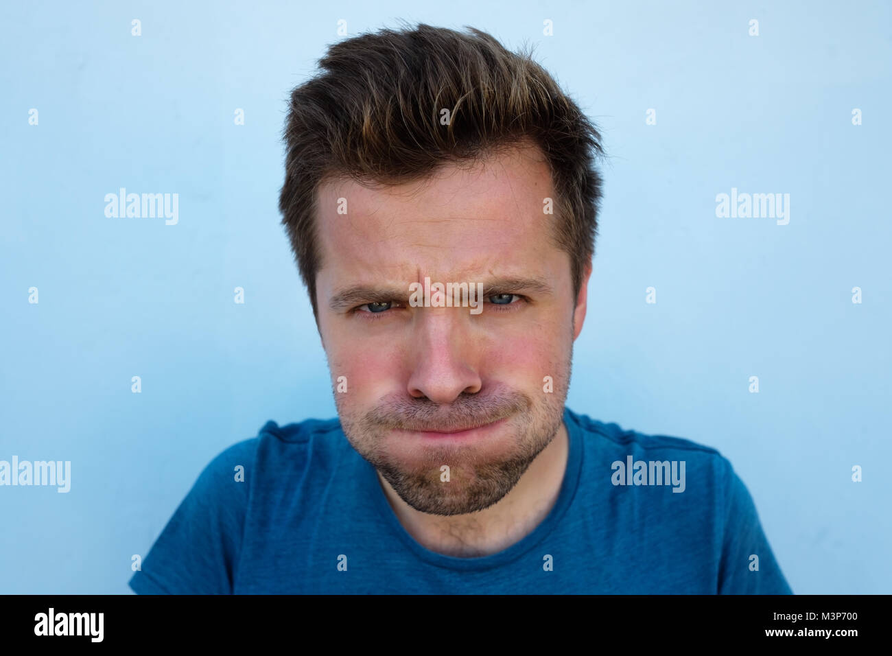 Humorous emotional portrait of grimacing young man Stock Photo