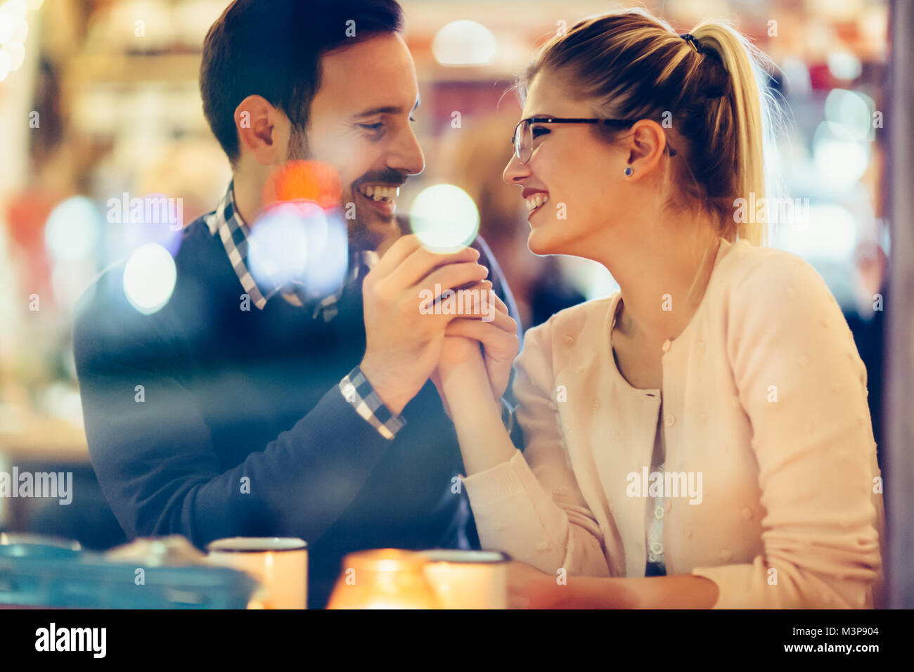 Romantic couple dating in pub at night Stock Photo