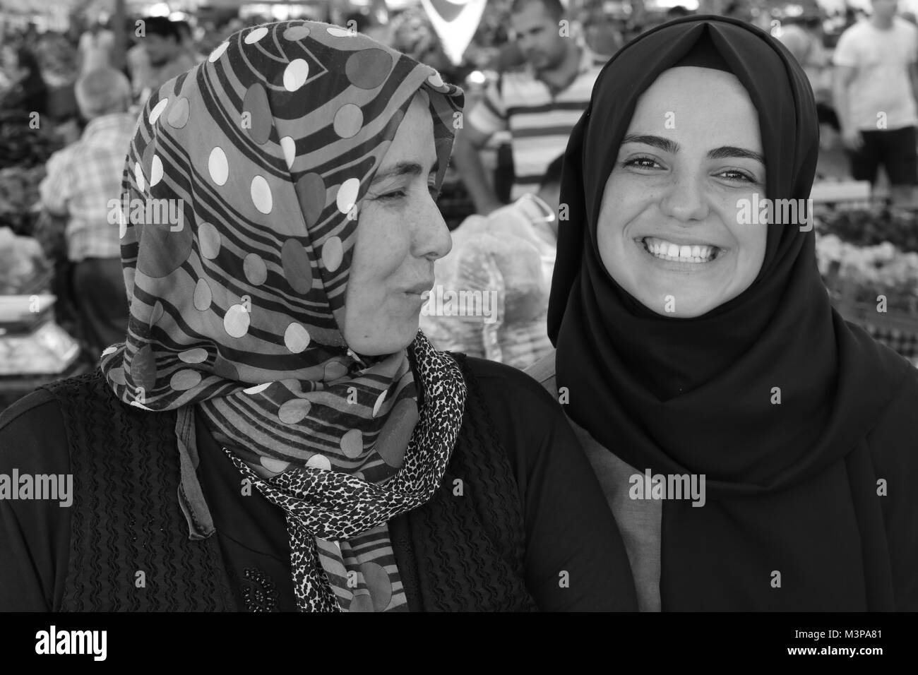 A portrait of a young turkish girl and her mother working at a fresh fruit and vegetable produce market in Calis, Turkey Stock Photo