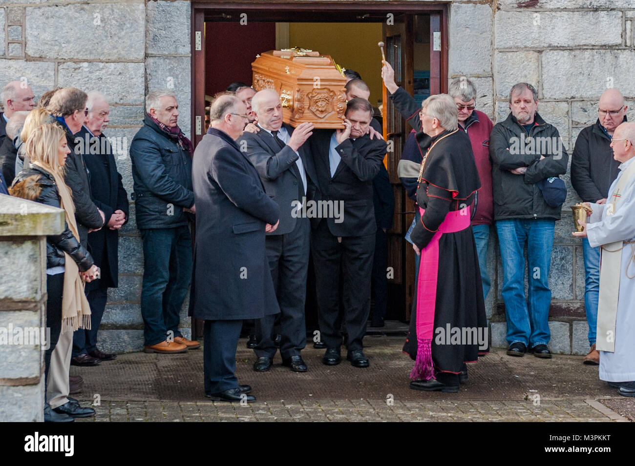 Ovens, Ireland. 12th Feb, 2018. The funeral of footballer Liam Miller took place today at St. John the Baptist Church, Ovens, County Cork, Ireland. A huge number of mourners attended the funeral, including many footballers and managers from Miller's old clubs, including Cork City, Celtic and Manchester United. Bishop John Buckley sprinkles Holy Water over Liam Miller's coffin after the funeral. Credit: Andy Gibson/Alamy Live News. Stock Photo