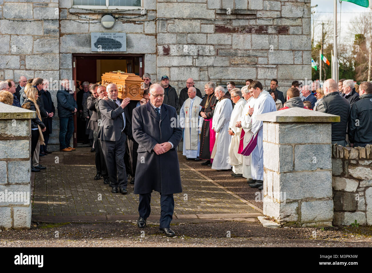 Ovens, Ireland. 12th Feb, 2018. The funeral of footballer Liam Miller took place today at St. John the Baptist Church, Ovens, County Cork, Ireland. A huge number of mourners attended the funeral, including many footballers from Miller's old clubs, including Cork City, Celtic and Manchester United. The coffin of Liam Miller is carried to his final resting place in the graveyard at St. John The Baptist Church. Credit: Andy Gibson/Alamy Live News. Stock Photo