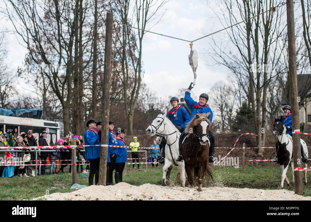 Bochum, Germany, 12 February 2018.  Bochum, Germany. 12th Feb, 2018. The day's winner of the traditional geese riding of the Geese Rider Club Sevinghausen, Joerg Wendorf (2-R), reaches for the wooden goose in Bochum, Germany, 12 February 2018. The custom of geese riding is to be gotten to the Bochum region from Spanish soldiers in the 16th century. Thereby, a dead geese was hung up at a height of several metres, with her head hanging downwards.  Credit: Bernd Thissen/dpa/Alamy Live News Stock Photo