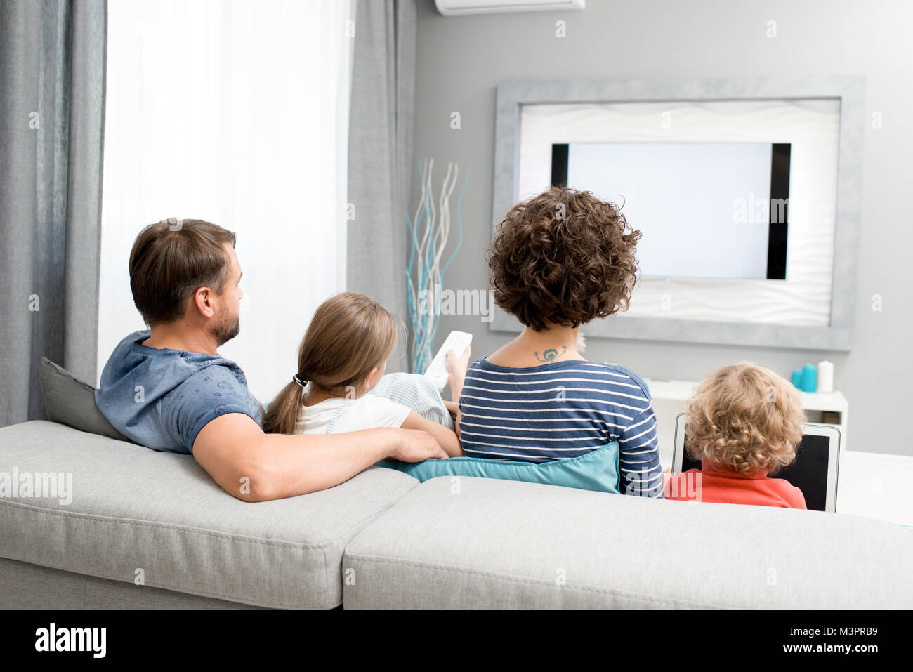 Family Watching TV in Living Room Stock Photo - Alamy