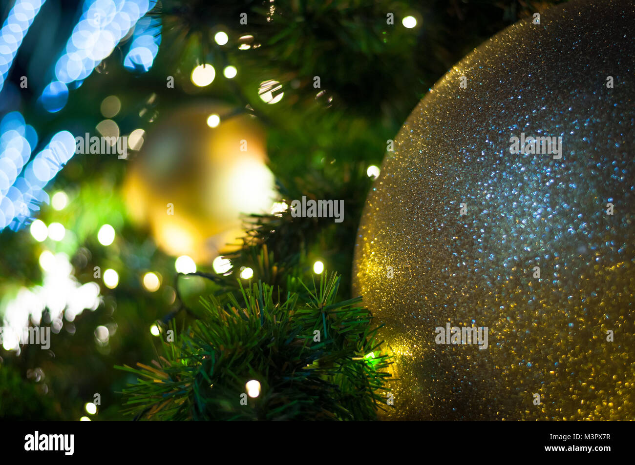 Close up big yellow glitter ball christmas on tree with wire white ...