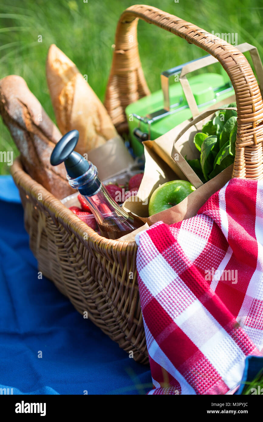 Summer picnic basket with snacks on green grass for meal with outdoor ...