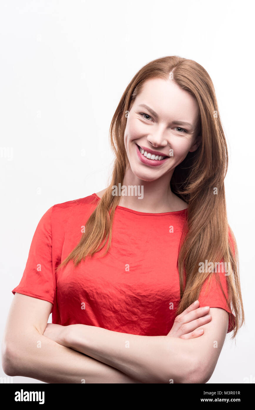 Ginger-haired woman folding her arms across chest Stock Photo