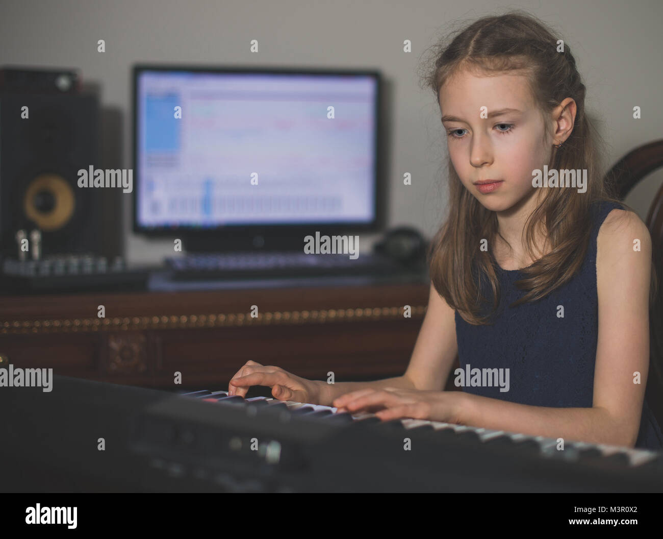 Little girl recording song on piano in home music studio Stock Photo