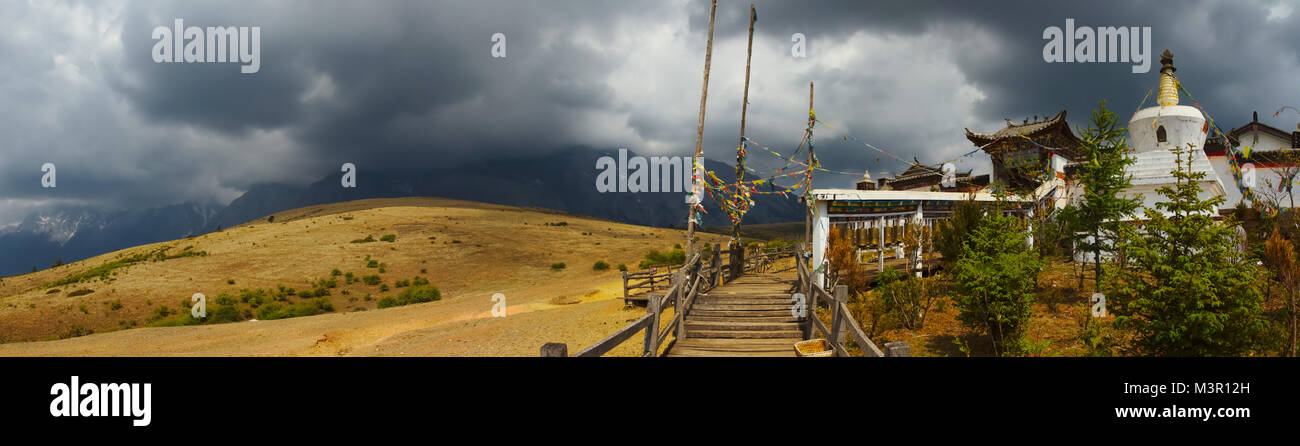 Storm clouds gathering in the mountain. temple and Snow Jade mountain in the background, Lijiang, Yunnan province, China. Stock Photo