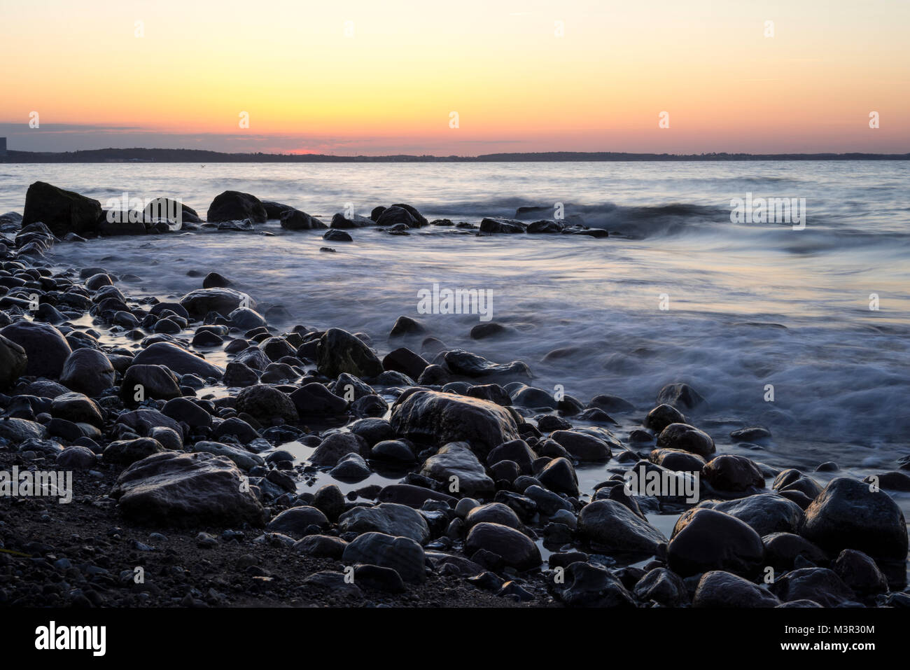 Sunset at a rocky beach in northern Germany, Niendorf, Schleswig-Holstein Stock Photo