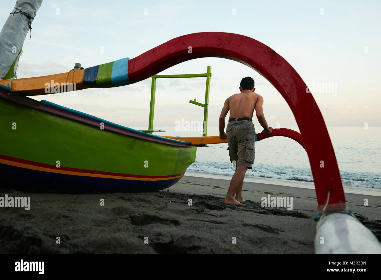 Local fisherman with fishing kayak boat at Lombok beach Indonesia Stock Photo