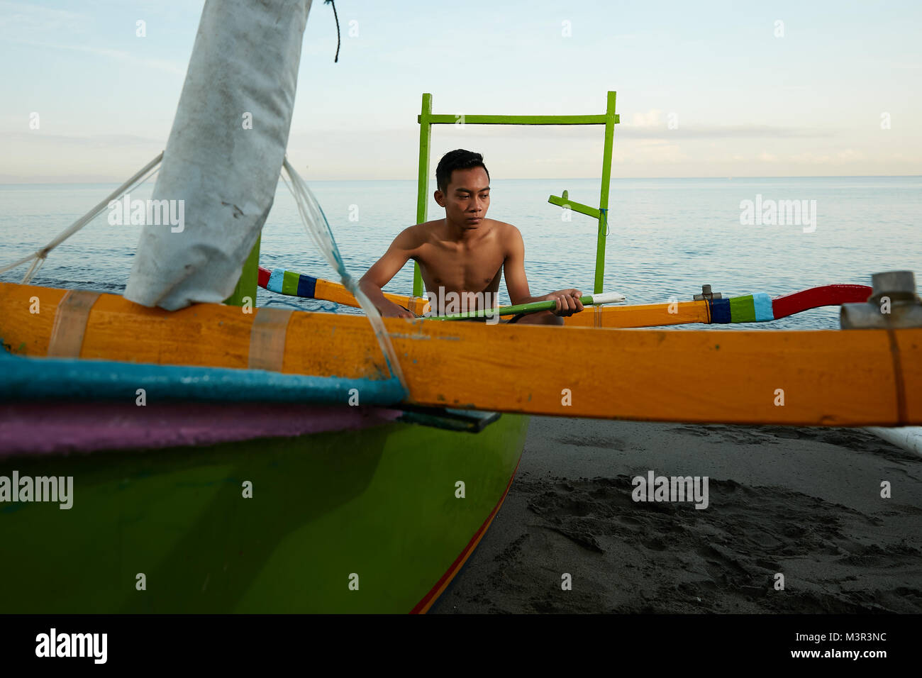 Local fisherman with fishing kayak boat at Lombok beach Indonesia Stock Photo