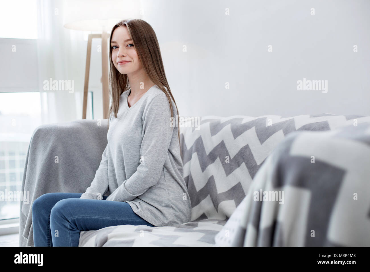 Smiling girl relaxing on the sofa Stock Photo - Alamy