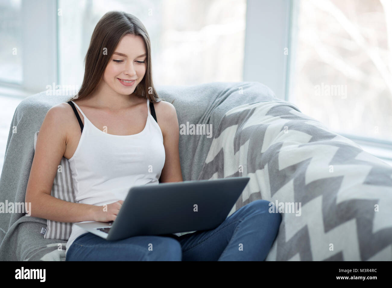 Smiling girl relaxing with her computer Stock Photo - Alamy