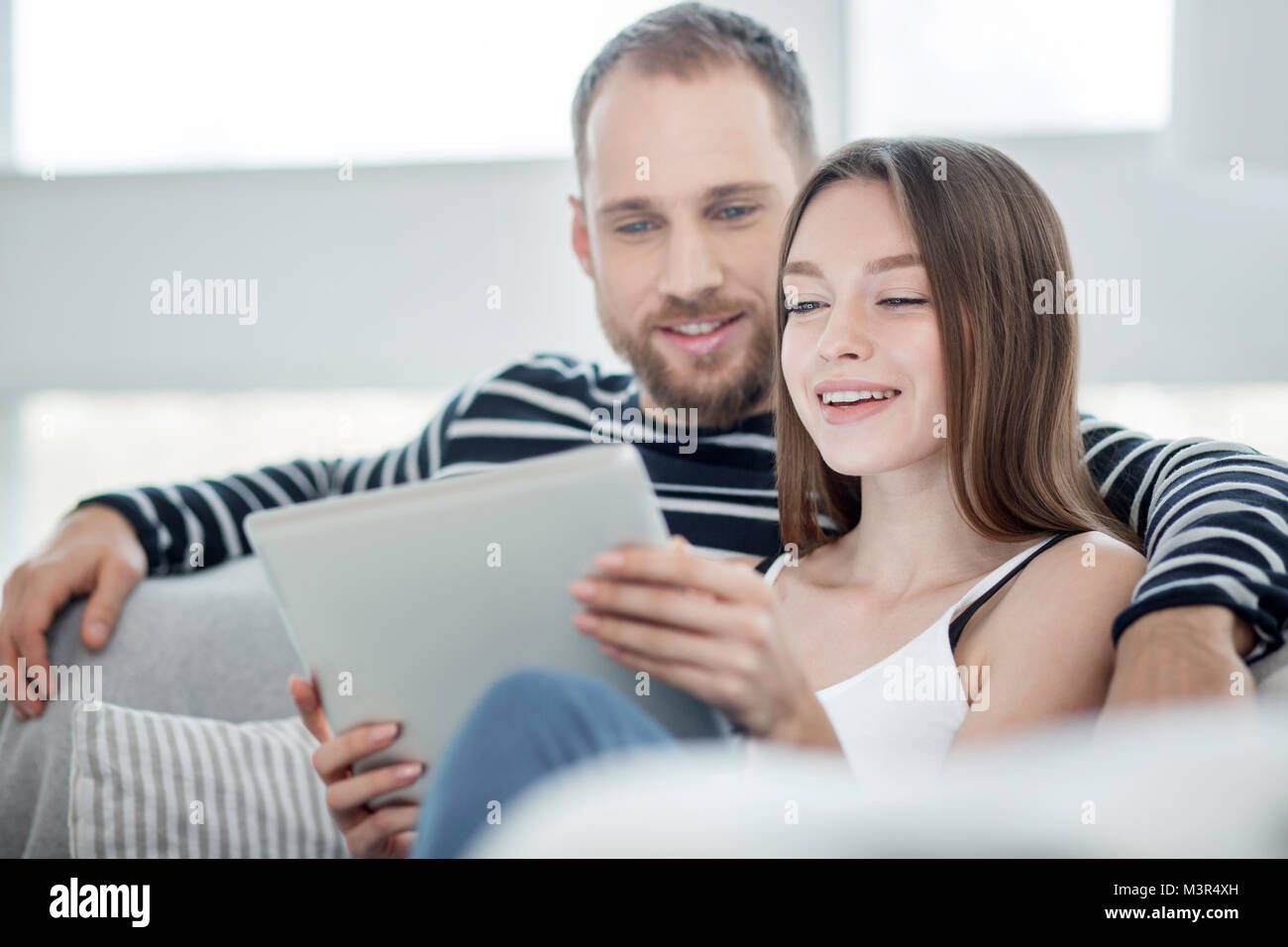Happy couple relaxing together on the couch Stock Photo - Alamy