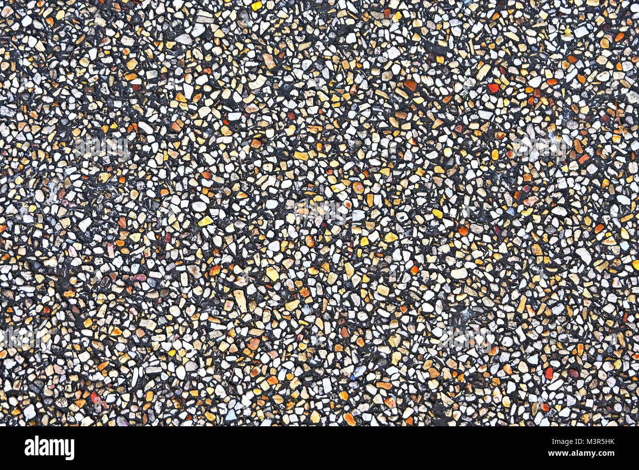 Small pebbles embedded in the concrete, colourful pebbles texture and background Stock Photo