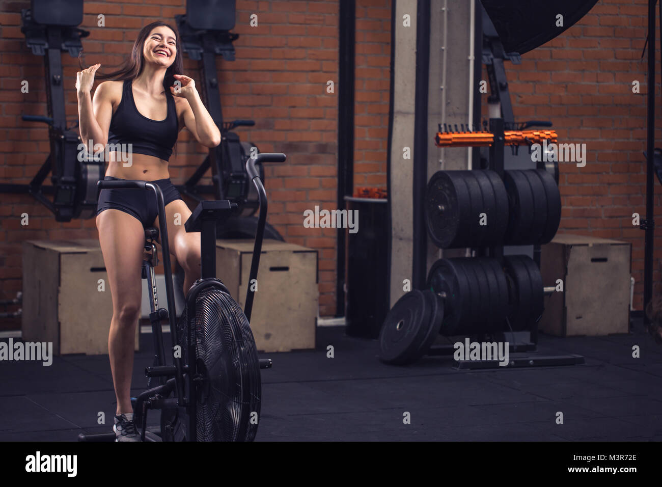 woman riding an exercise bike in gym. fit girl doing cardio training on