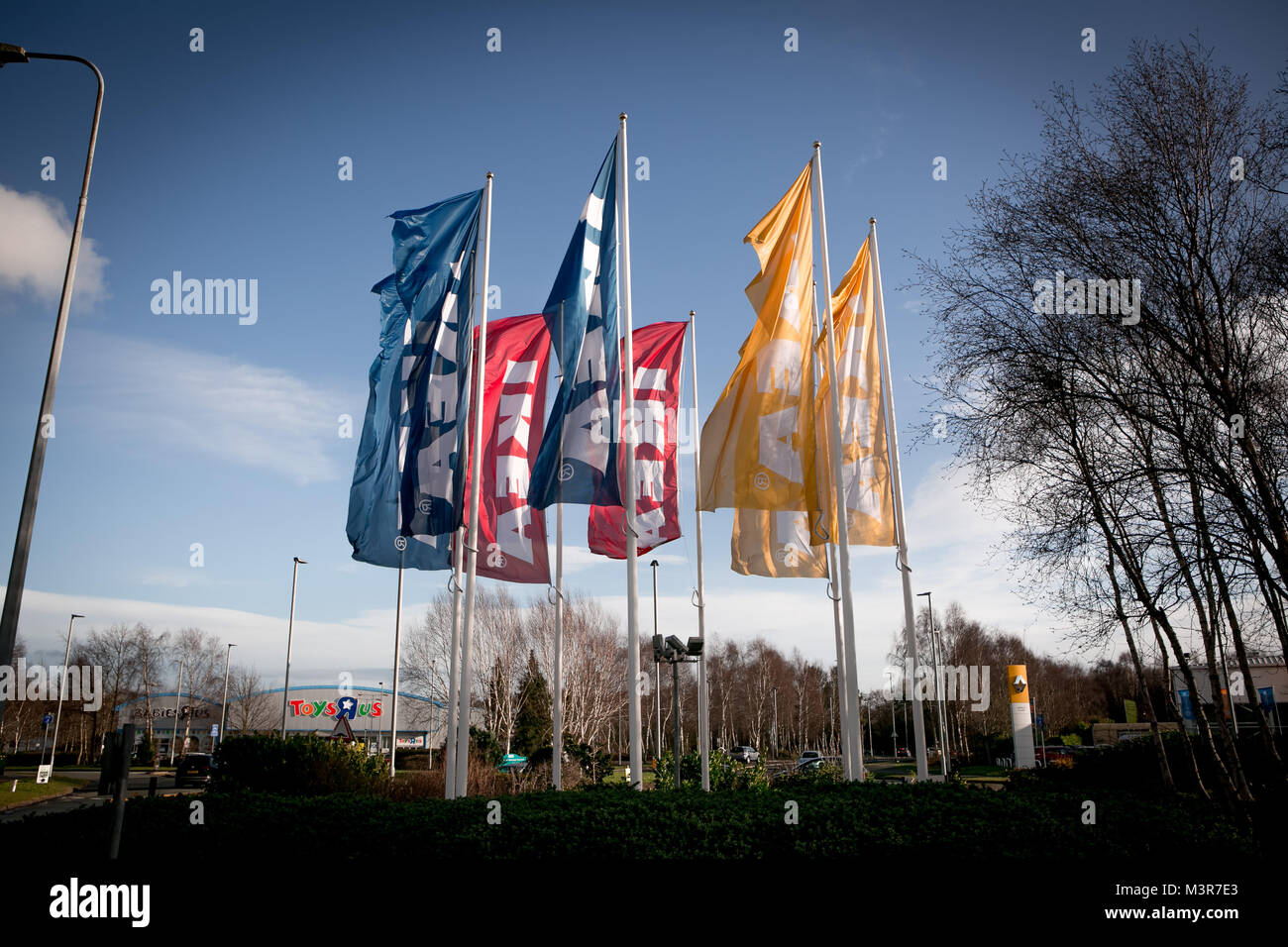 Yellow, blue & red IKEA flags outside store. Warrington, UK. Taken 12th February 2018 after IKEA founder Ingvar Kamprad died aged 91. Stock Photo