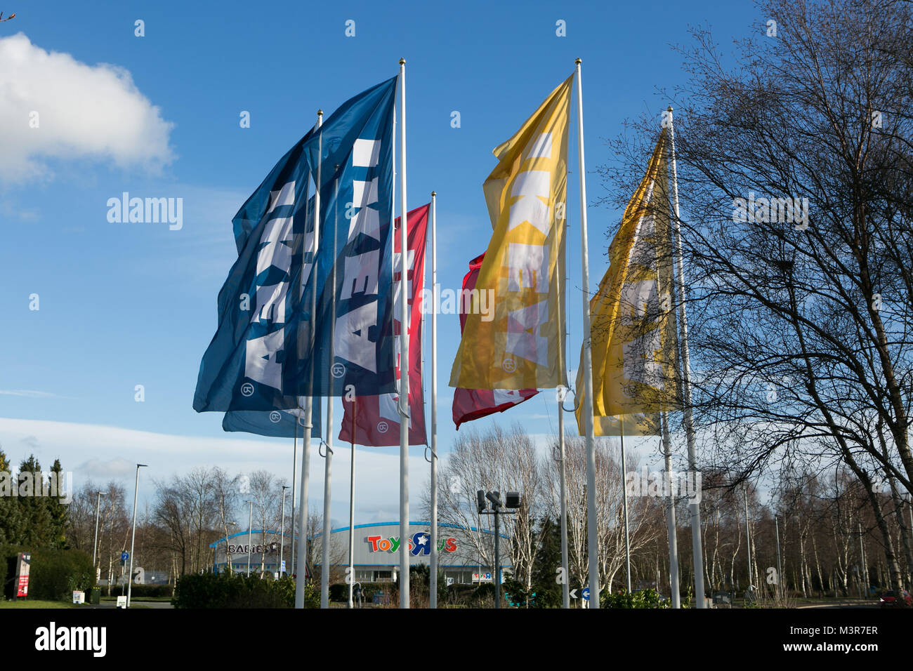 Yellow, blue & red IKEA flags outside store. Warrington, UK. Taken 12th February 2018 after IKEA founder Ingvar Kamprad died aged 91. Stock Photo