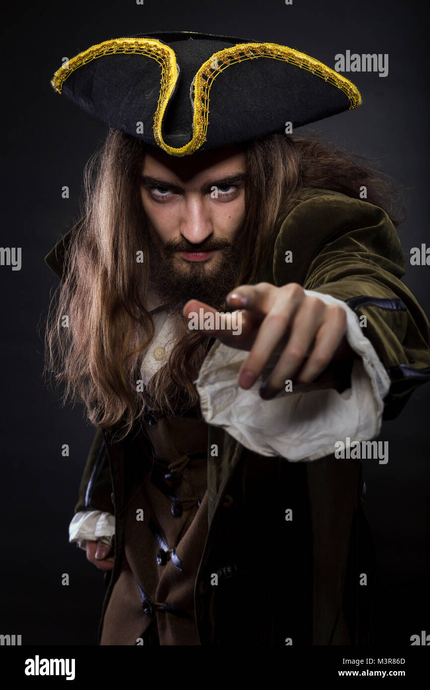 portrait of bearded and hairy pirate pointing into the viewer, shallow ...