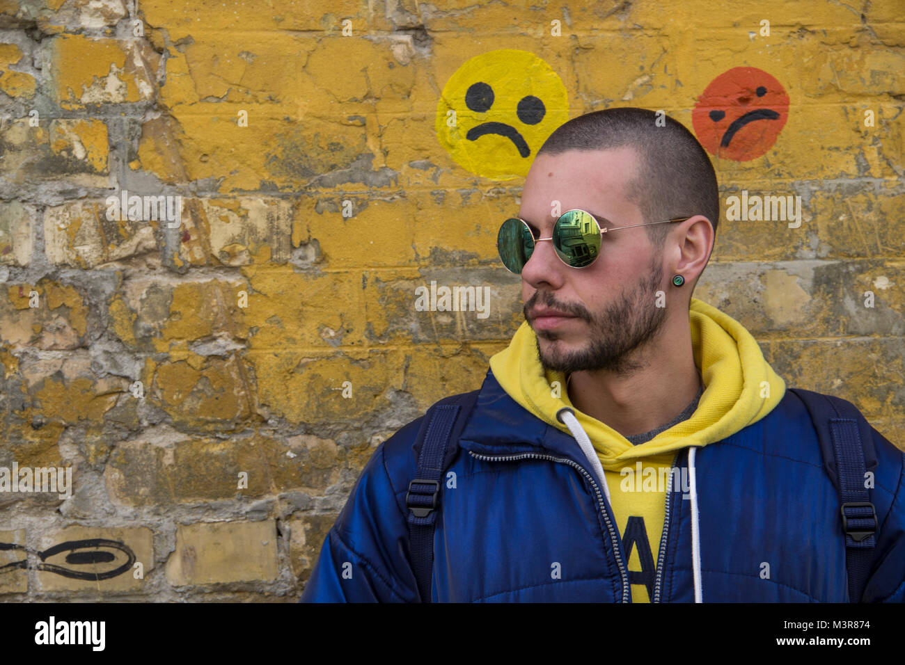 Portrait Of A Young Man In A Blue Jcket With Yellow Hood Stock Photo