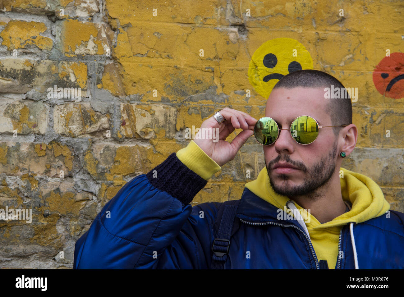 Portrait Of A Young Man In A Blue Jcket With Yellow Hood Stock Photo