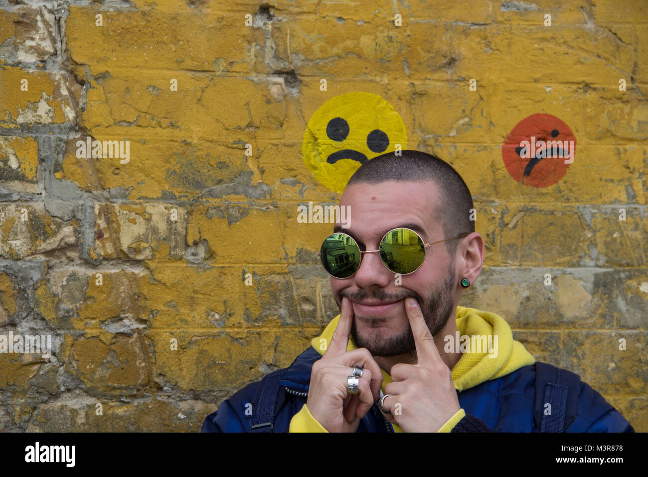 Portrait Of A Young Man In A Blue Jcket With Yellow Hood Stock Photo