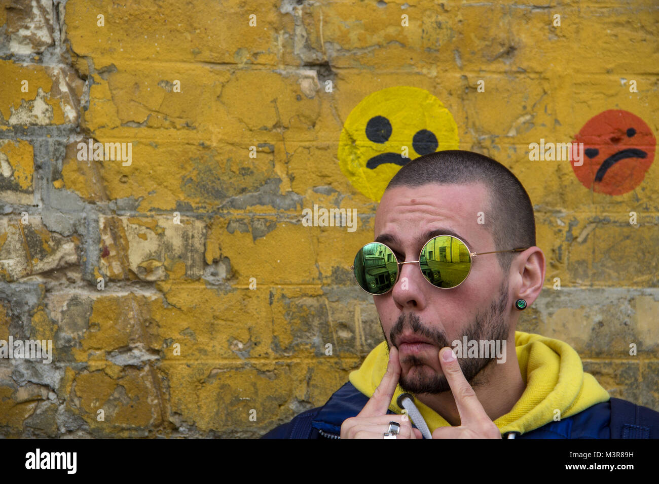 Portrait Of A Young Man In A Blue Jcket With Yellow Hood Stock Photo