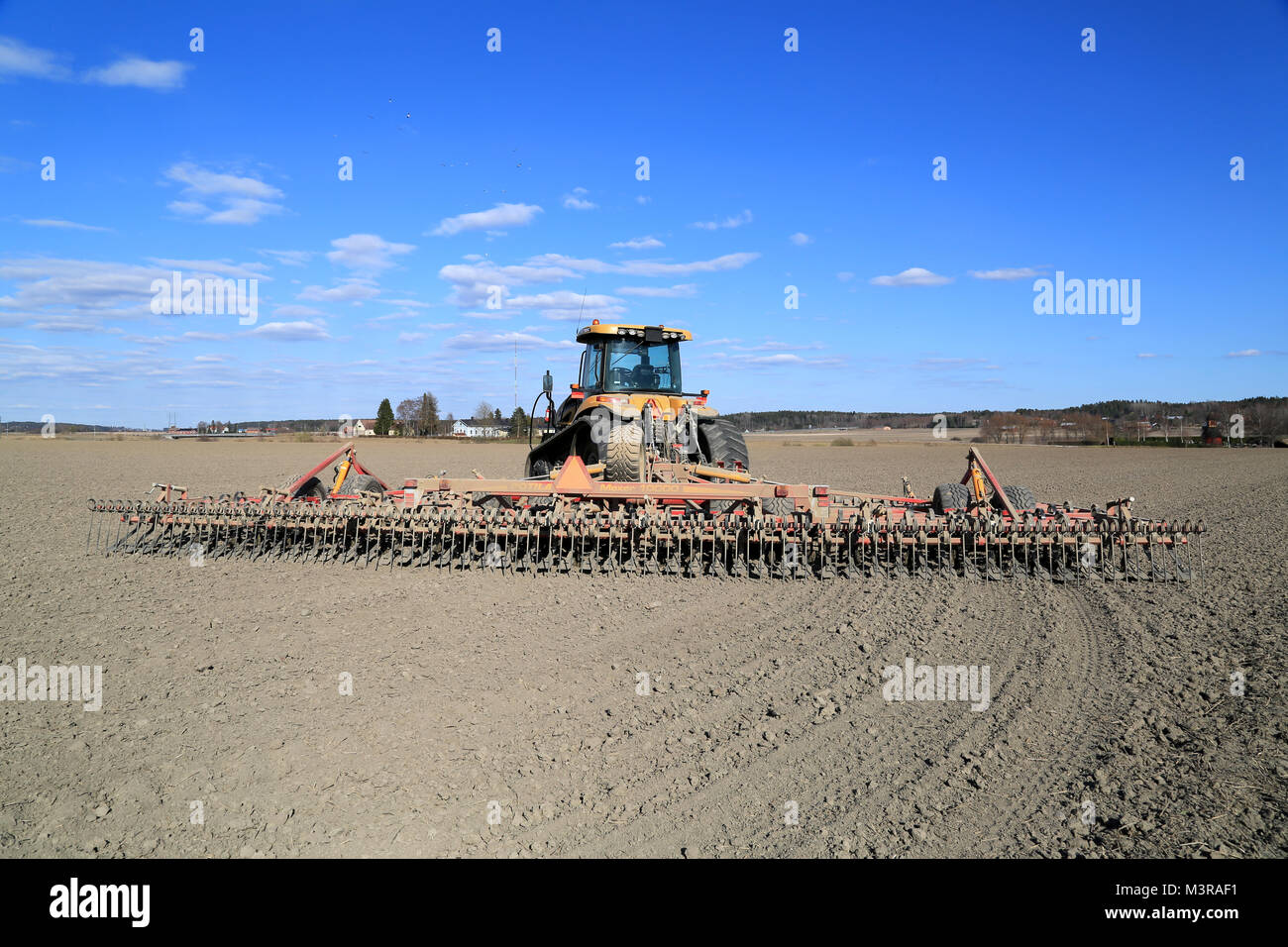SALO, FINLAND – APRIL 19, 2014: Potila Maxer 10000 seedbed cultivator and Caterpillar Challenger MT765c agricultural crawler tractor. Potila Maxer 100 Stock Photo