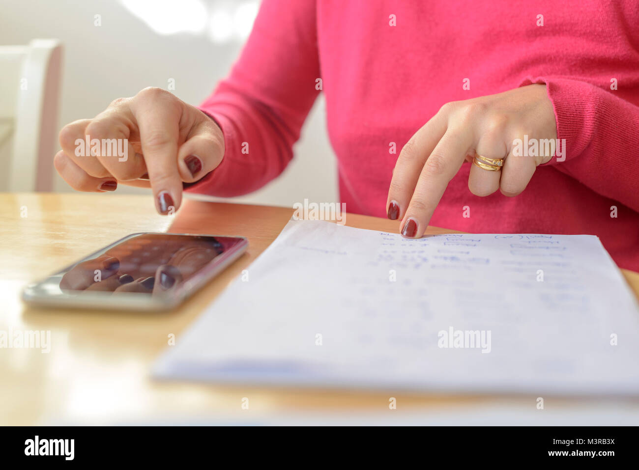 Self employedwoman calculates tax return at home Stock Photo