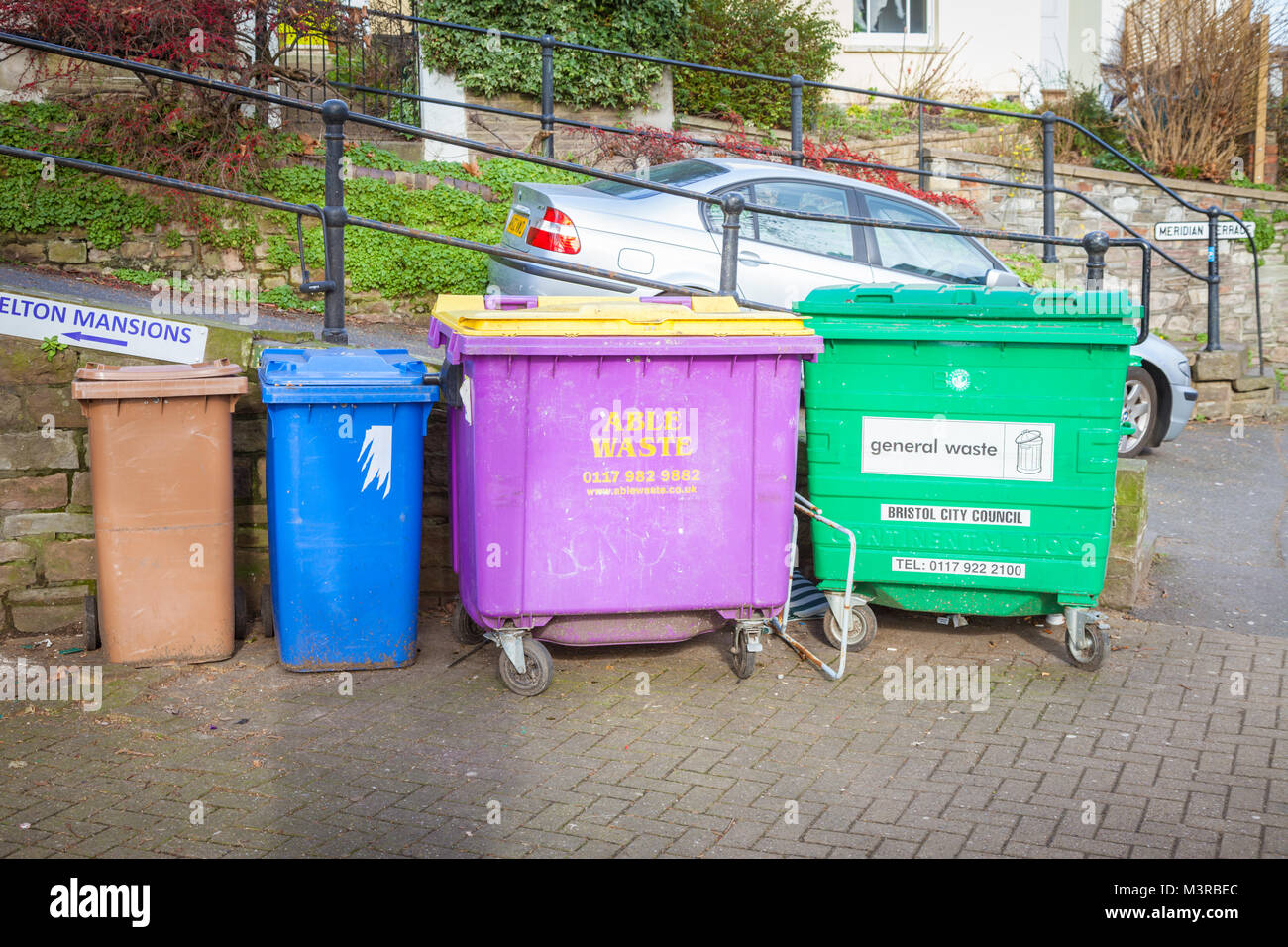 Four different coloured waste rubbish bins for collection on the street uk Stock Photo