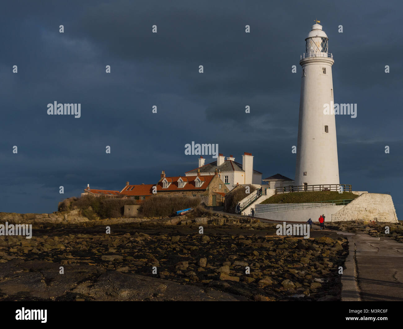 St Marys lighthouse Whitley Bay Newcastle upon Tyne, Northumberland, on a sunny winter morning beneath storm clouds Stock Photo