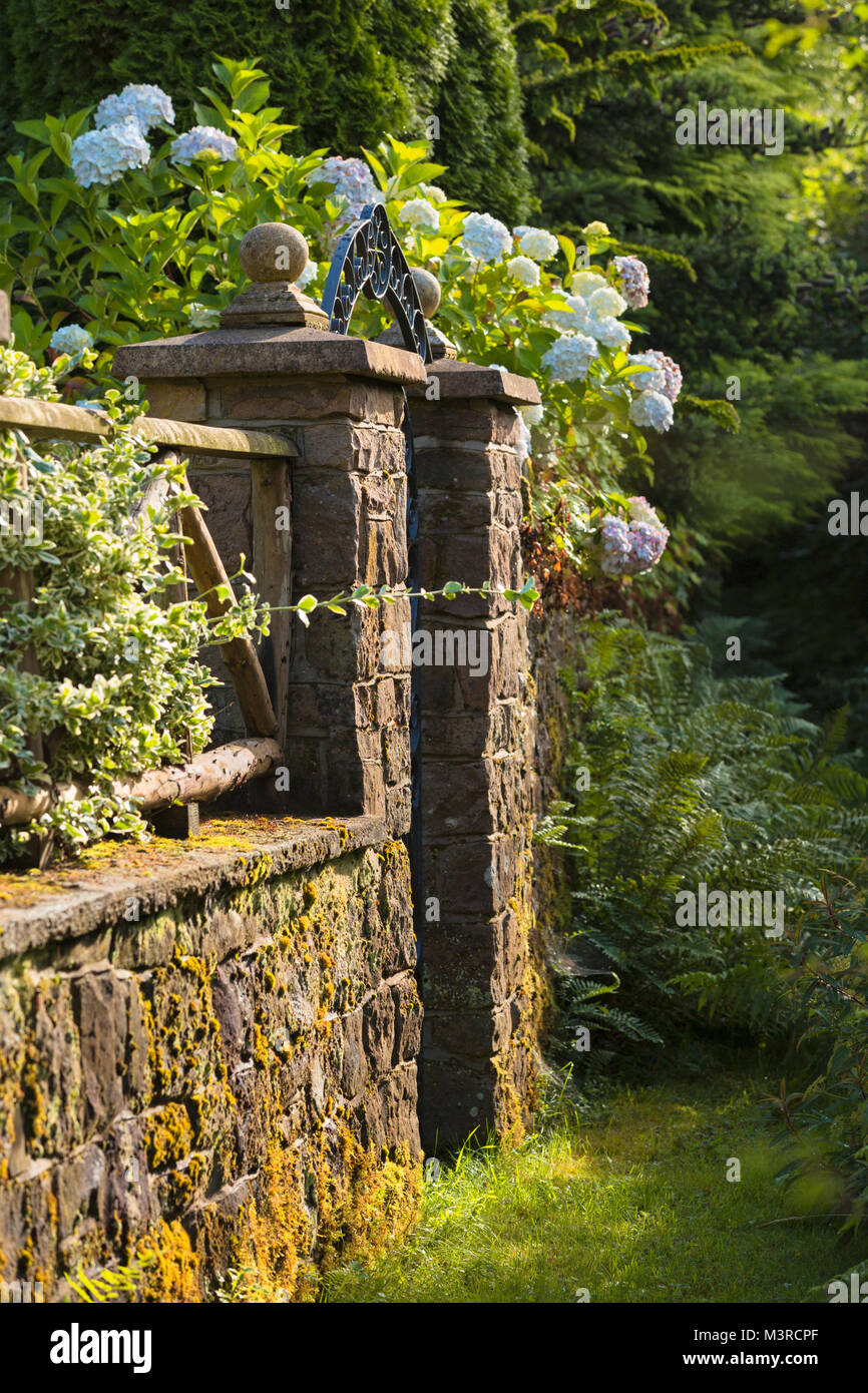 Stone gate pillars on a walled garden. Stock Photo