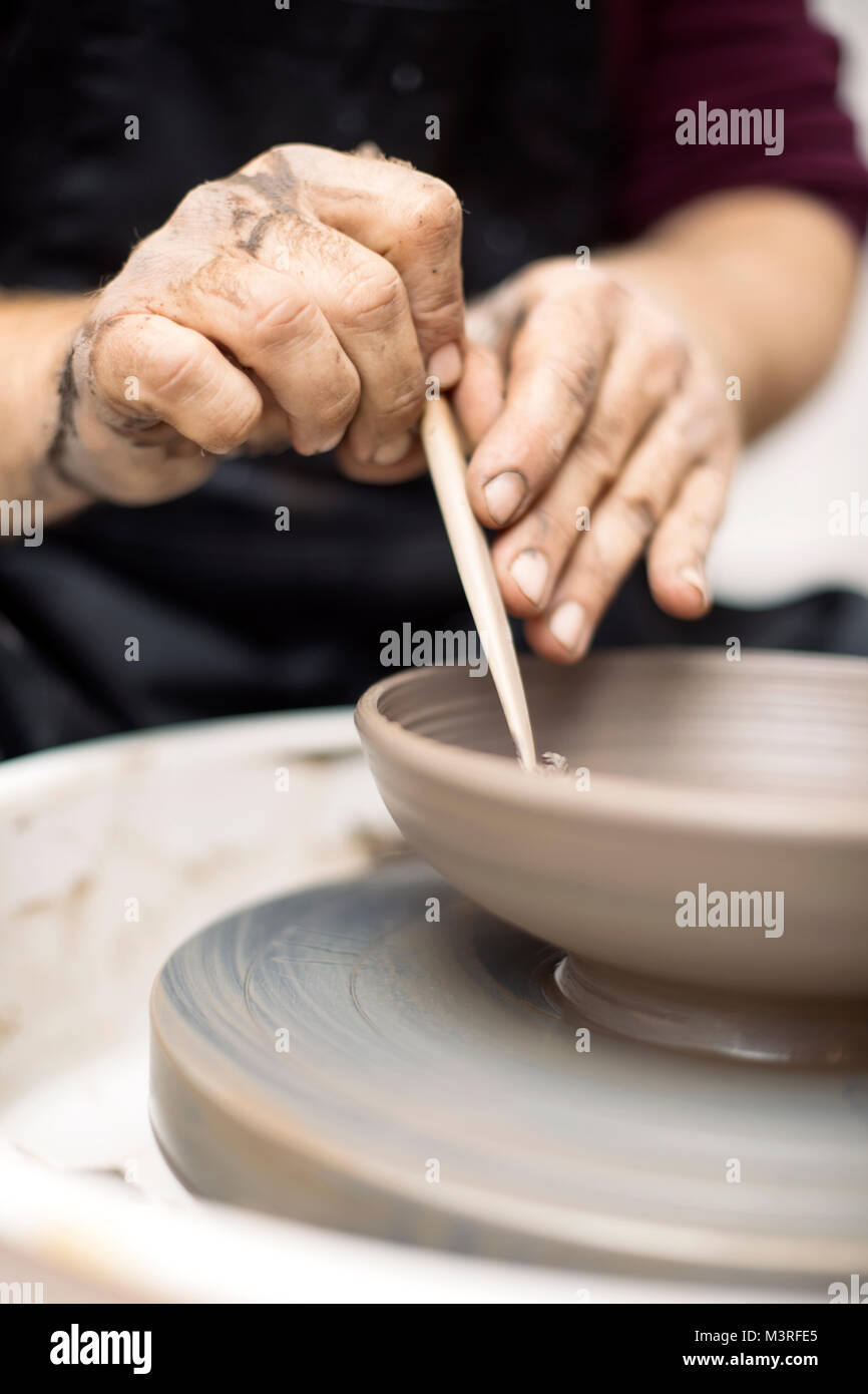 Close up detail view at an artist makes clay pottery on a spin wheel