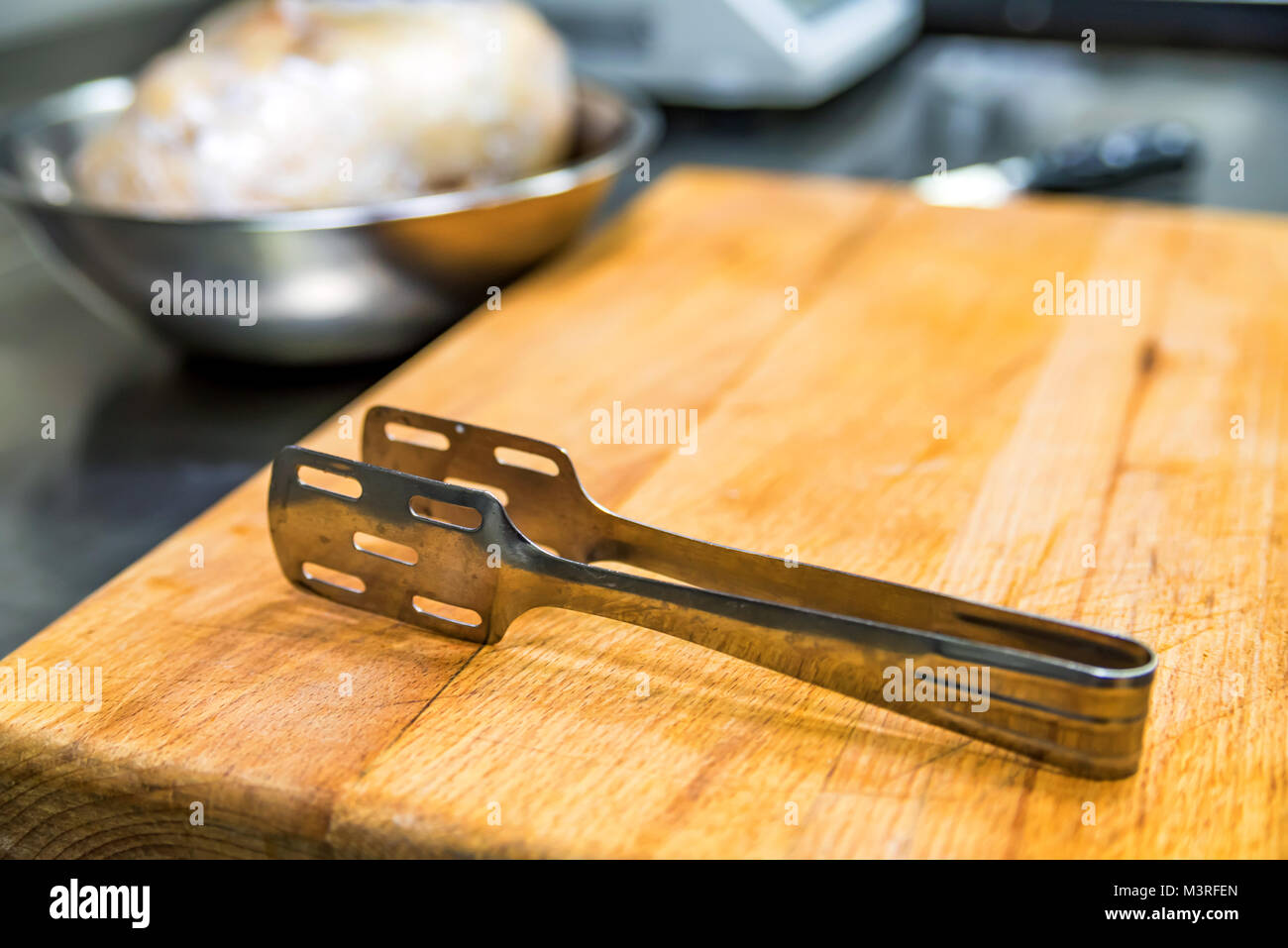 https://c8.alamy.com/comp/M3RFEN/metal-kitchen-thongs-on-wooden-board-M3RFEN.jpg