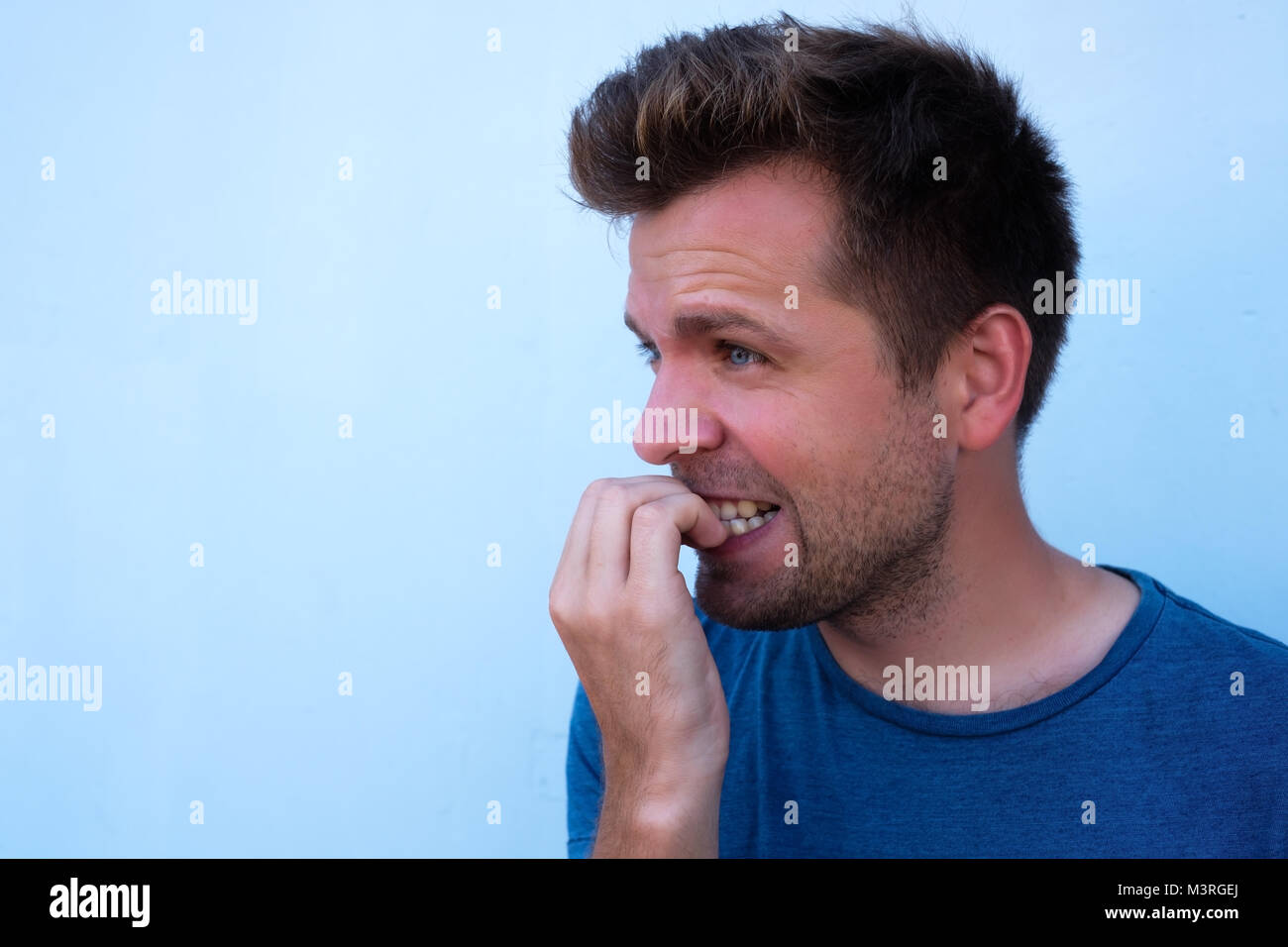 Caucasian mature man gnawing nails. Bad habit when you fell nervous and worry a lot. Stock Photo