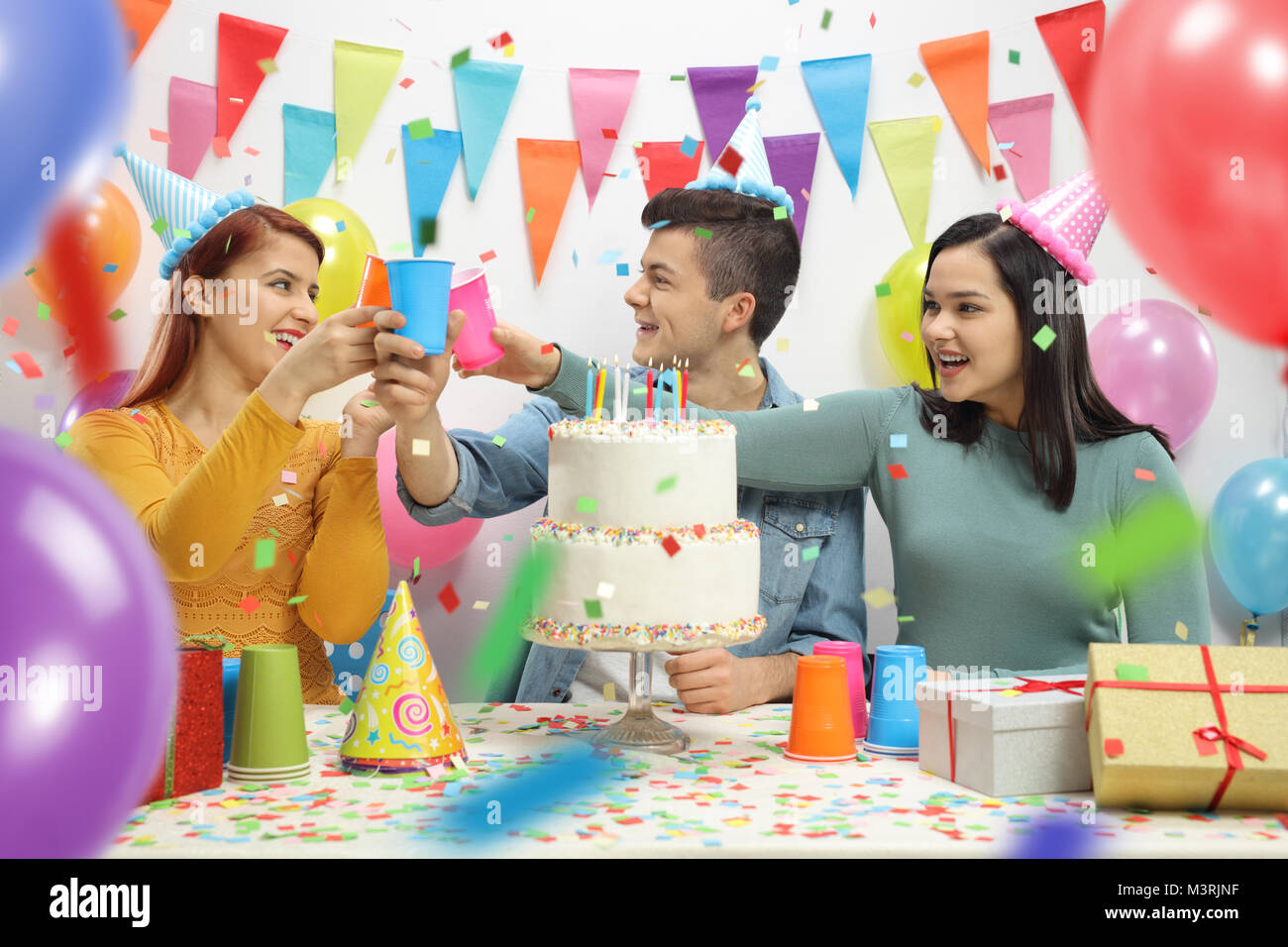 Cheerful teenagers celebrating a birthday and making a toast Stock Photo